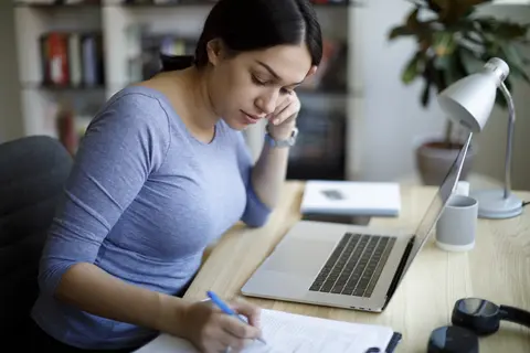 Junge Frau sitzt am Laptop